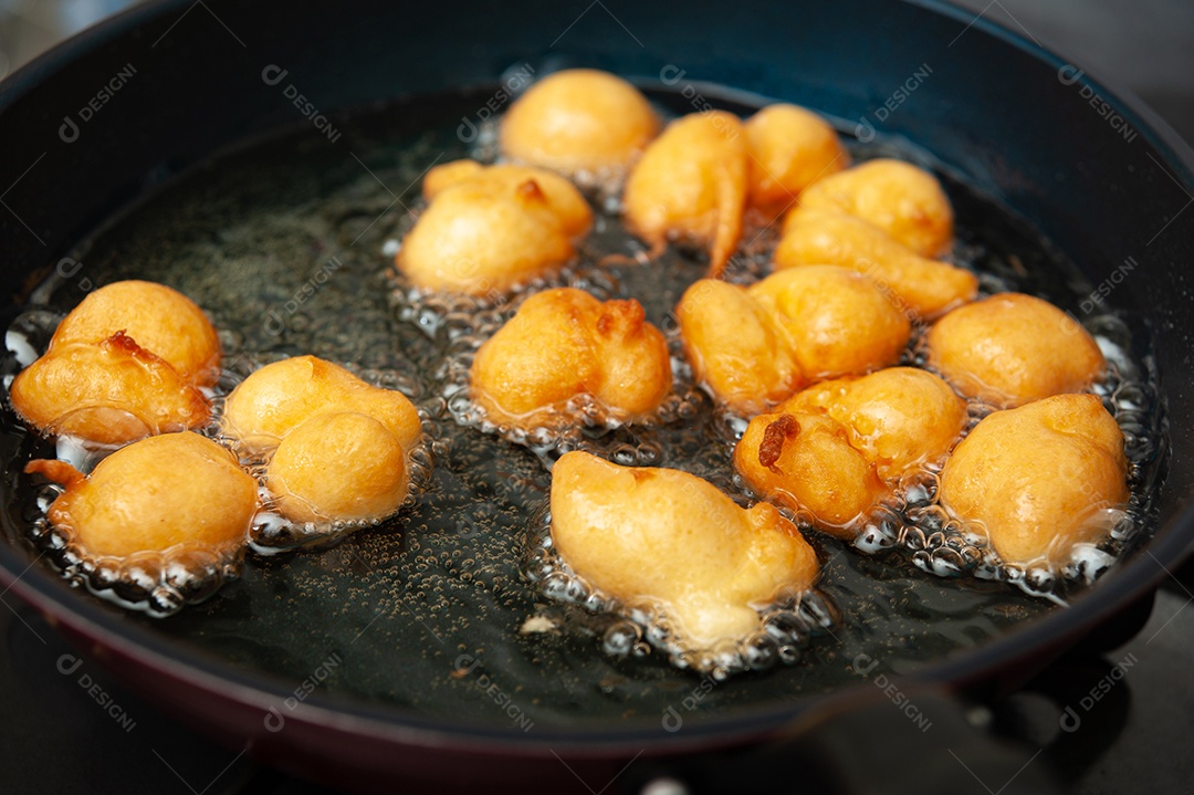 Delicioso e tradicional doce brasileiro caseiro chamado Bolinho de Chuva em um prato. Isolado em fundo de madeira. Vista do topo. Copiar espaço