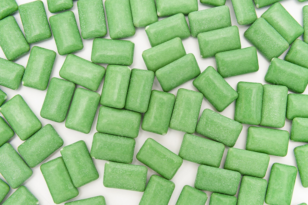 Pastilhas de goma de mascar de menta verde alinhadas. Isolado no fundo branco. Vista do topo.
