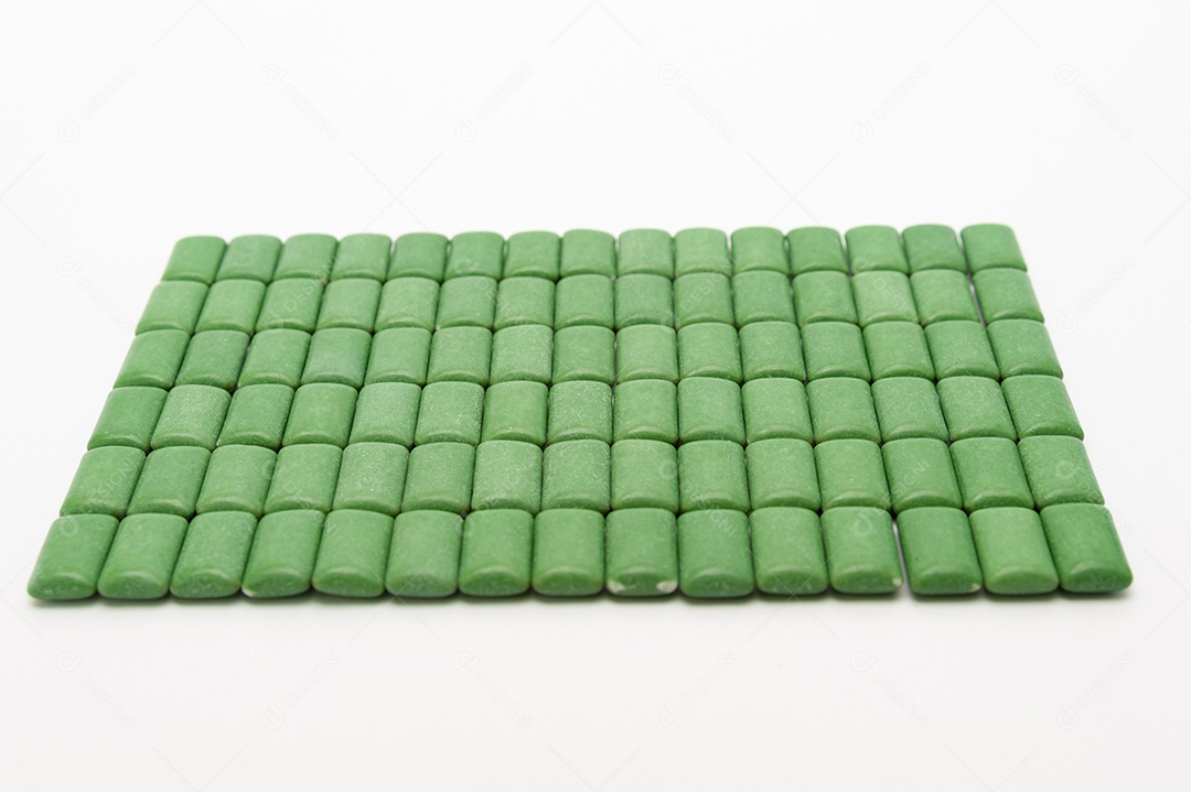 Green mint chewing gum lozenges lined up. Isolated on white background. View from the top.