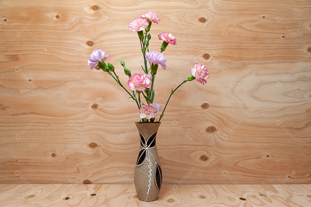 Lindo arranjo de flores de cravo japonês em pequeno vaso de cerâmica. Fundo de madeira. Copie o espaço. Tiro horizontal.