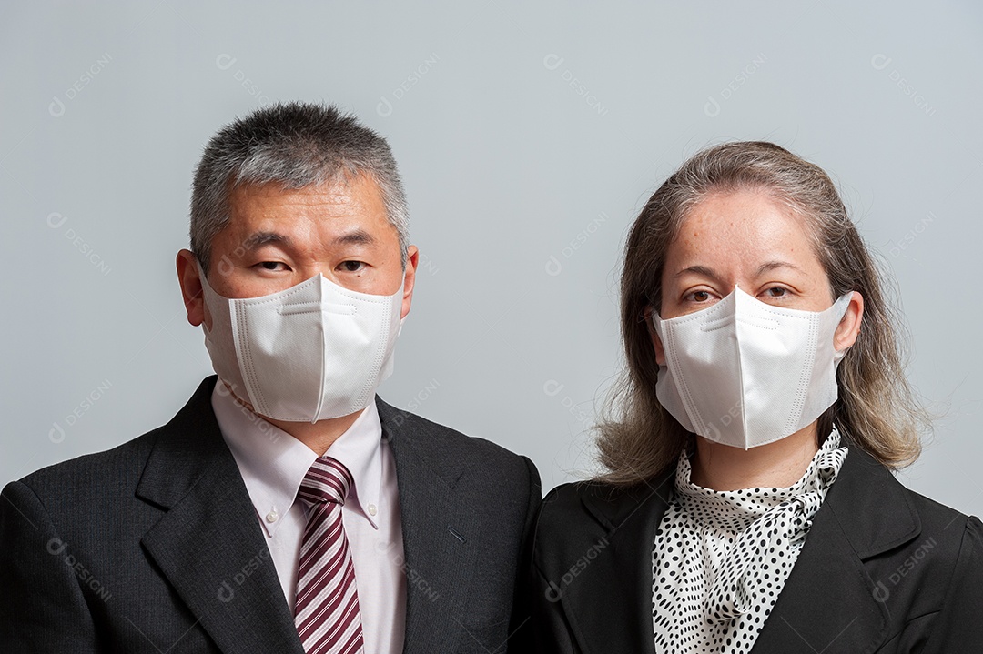 Vista frontal de um casal asiático de meia idade usando máscara cirúrgica branca proteção