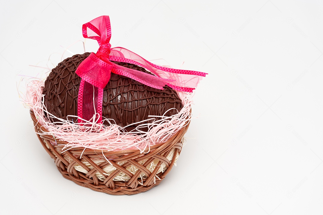 Ovo de chocolate na cesta de vime com lindo laço de fita vermelha. Celebração da Páscoa. Isolado no fundo branco. Copie o espaço. Tiro horizontal.