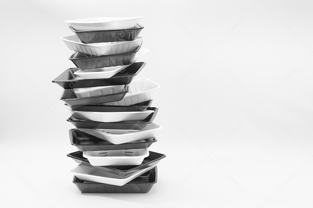 Bandejas de recipientes de alimentos de espuma branca e preta (bandejas de isopor) empilhadas. Isolado no fundo branco. Fechar-se. Copie o espaço. Tiro horizontal.