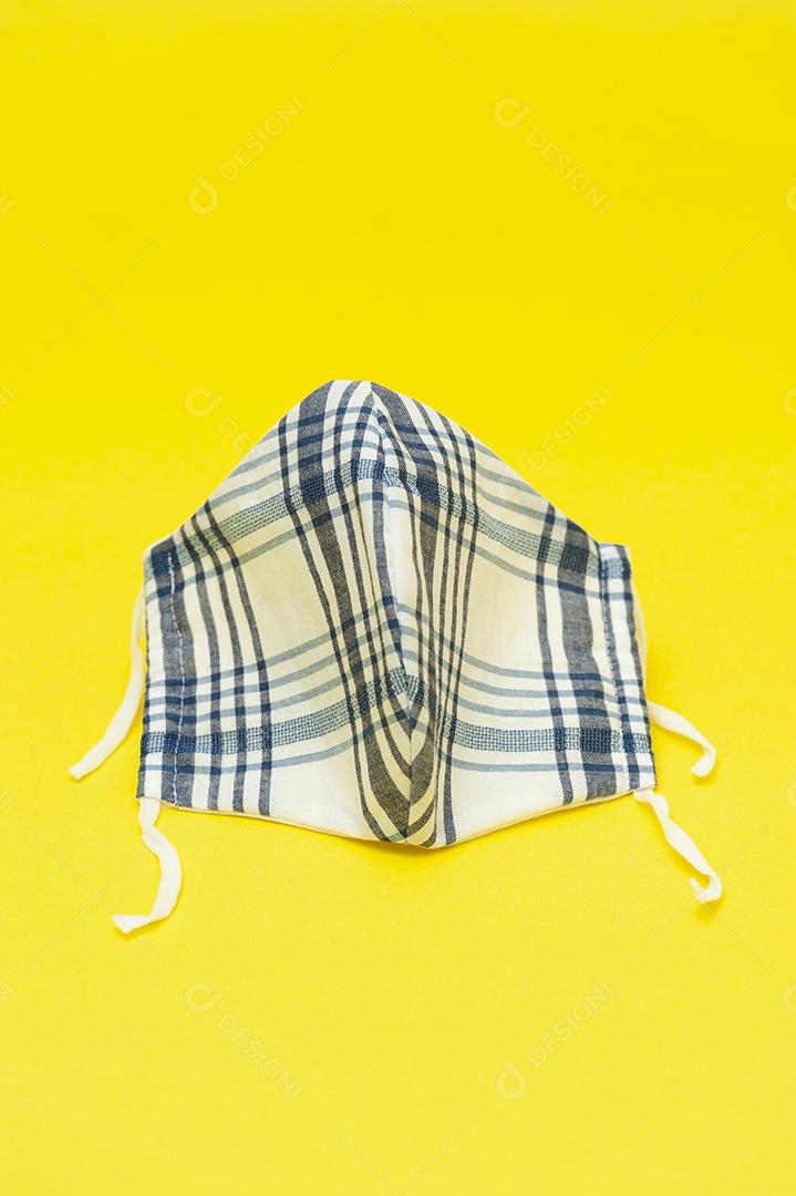 Máscara facial de tecido floral (branco, vermelho e salmão) DIY) para proteção contra coronavírus (COVID-19) e outras doenças infecciosas. Isolado em fundo vermelho. Copie o espaço. Tiro vertical.