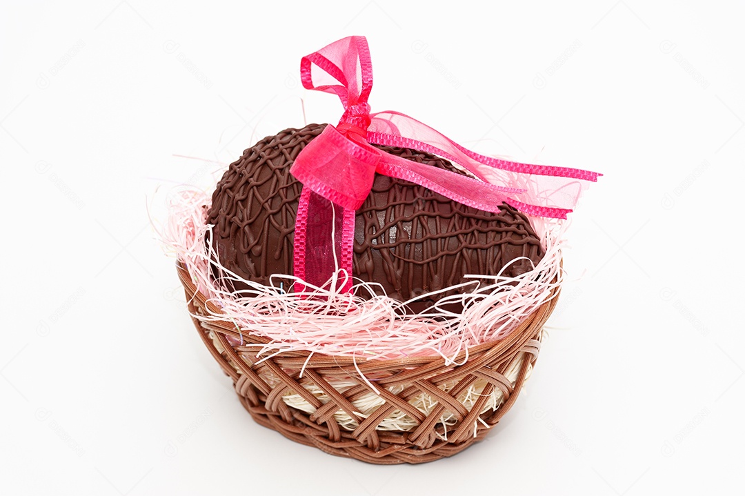 Ovo de chocolate na cesta de vime com lindo laço de fita vermelha. Celebração da Páscoa. Isolado no fundo branco. Fechar-se. Tiro horizontal.