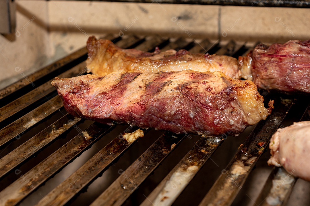 bifes de picanha e linguiça na grelha quente. maior ângulo