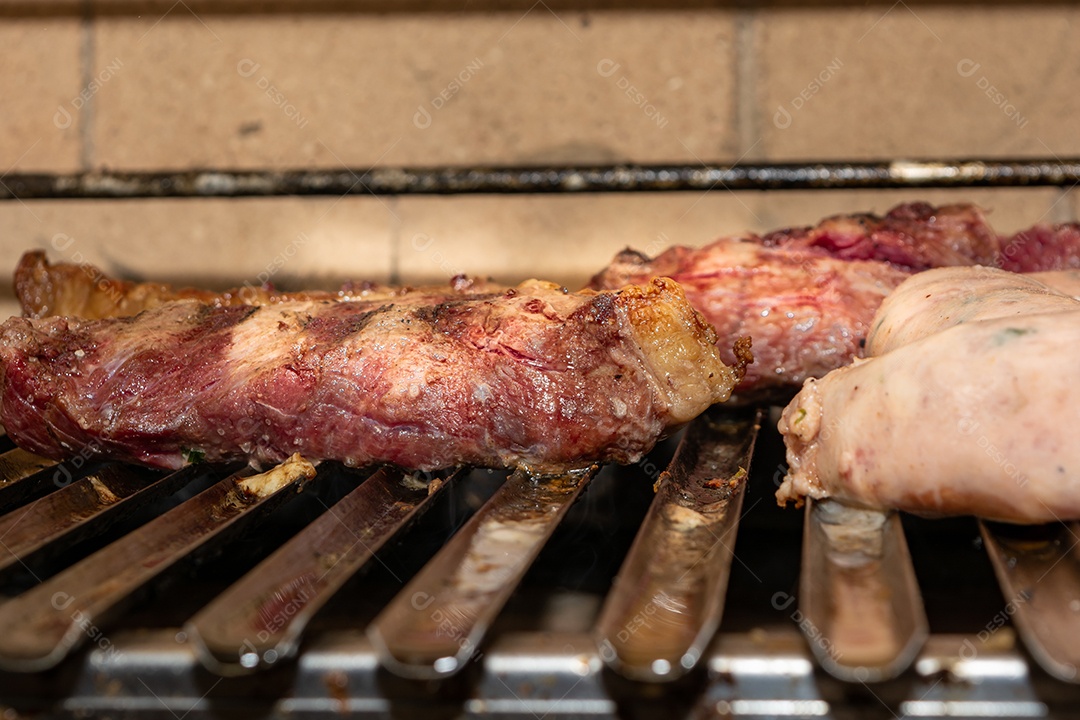 bifes de picanha e linguiça na grelha quente. maior ângulo