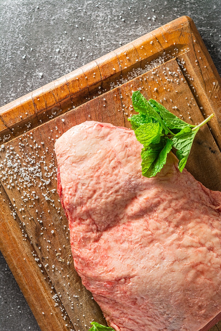 picanha inteira na tábua, vista superior com sal e folha verde