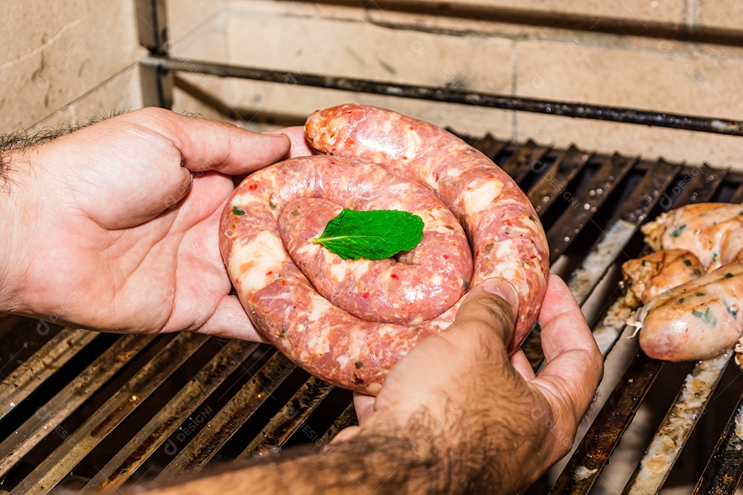 homem colocando salsicha crua na grelha, alto ângulo