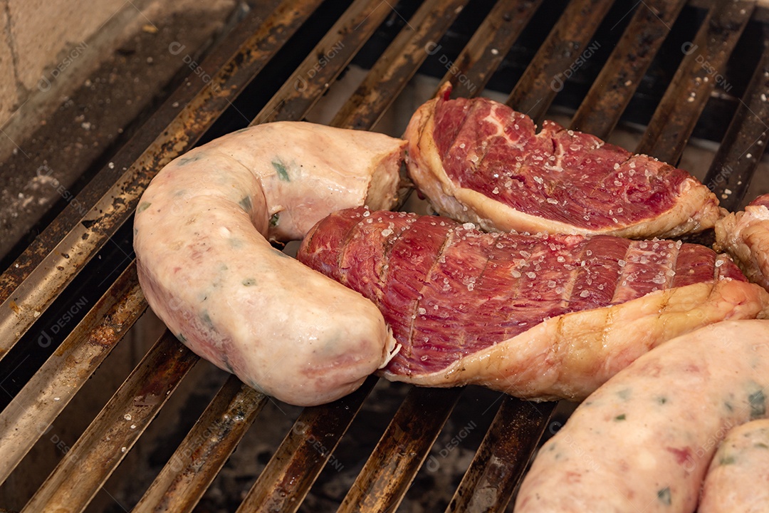 bifes de picanha e linguiça na grelha quente. maior ângulo