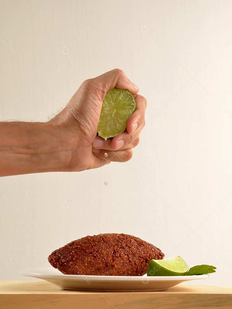 Quibes fritos sobre um prato branco mesa madeira