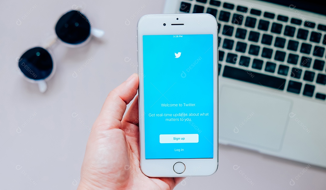 Mão segurando Apple iPhone 6s mostrando inscrição no aplicativo Twitter