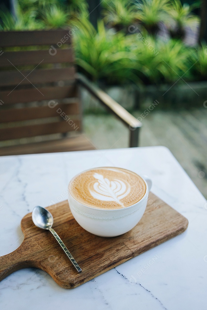 Xícara quente de café latte art serve na bandeja de madeira com colher