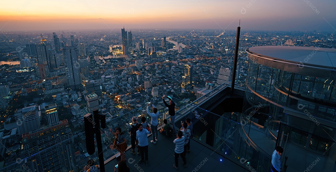 Muitos turistas apreciam o pôr do sol no telhado do edifício King Power Mahanakhon no alto de Bangkok