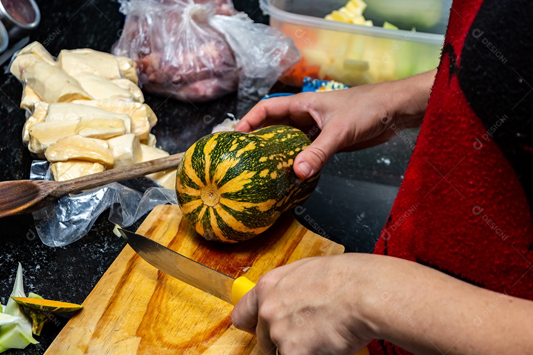 mulher na cozinha cortando e preparando abobrinha para o jantar, alto ângulo