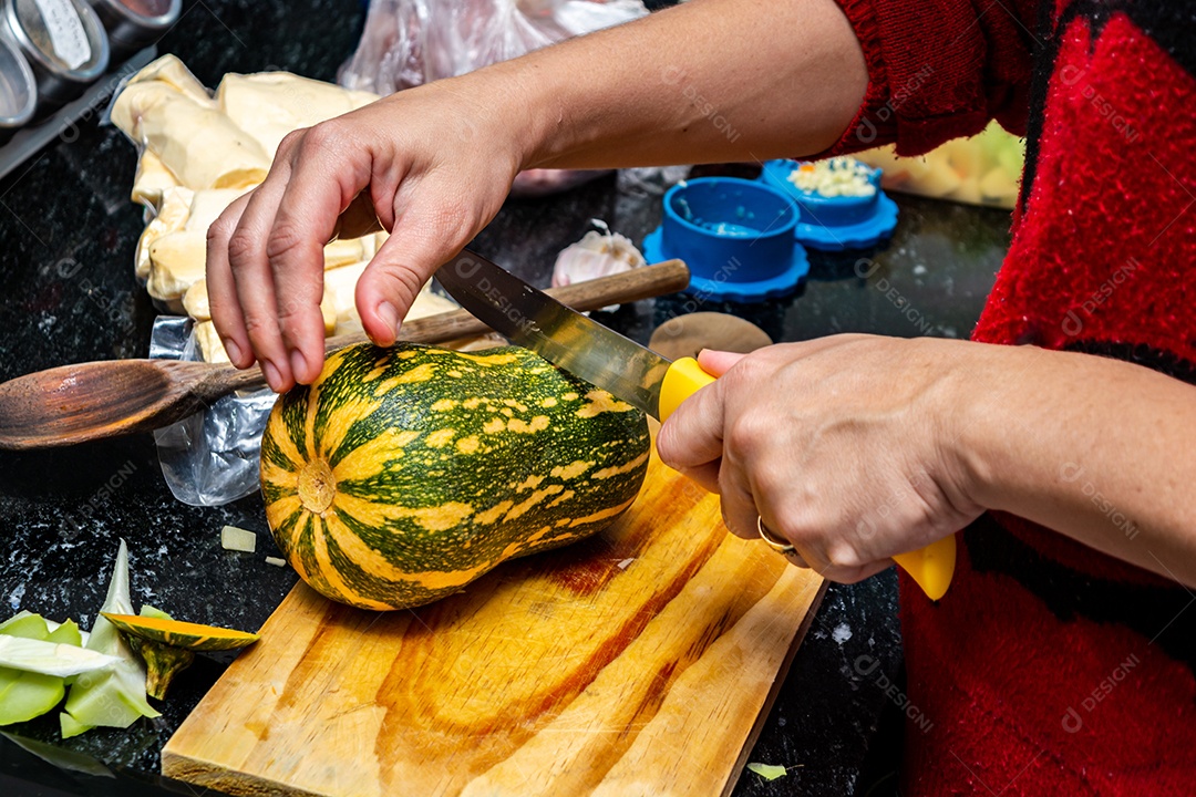 mulher na cozinha cortando e preparando abobrinha para o jantar, alto ângulo