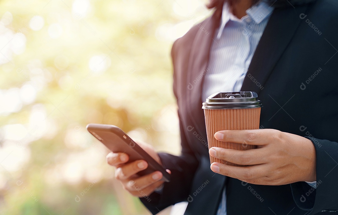 Close-up da empresária usando smartphone e bebendo café quente