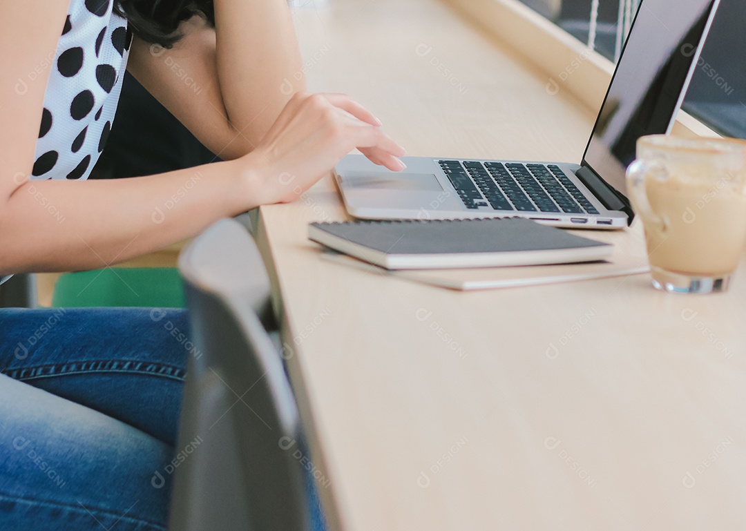 Close-up da jovem empresária digitando no computador portátil