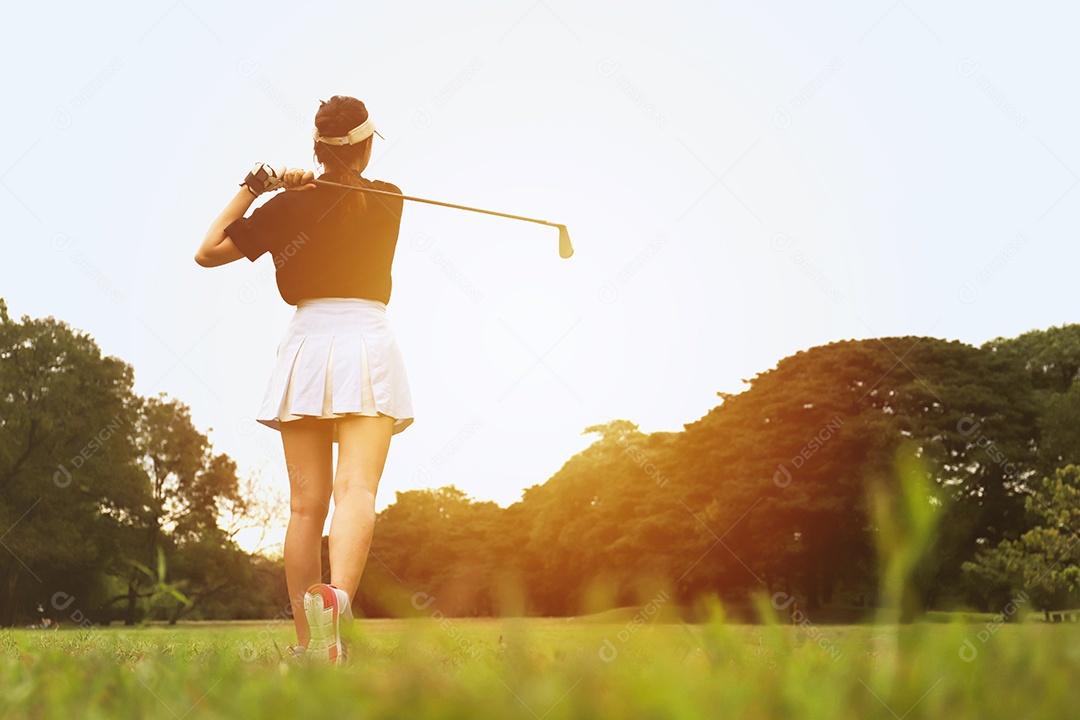Jogador de golfe mulher balançando tiro no curso no parque com sol quente