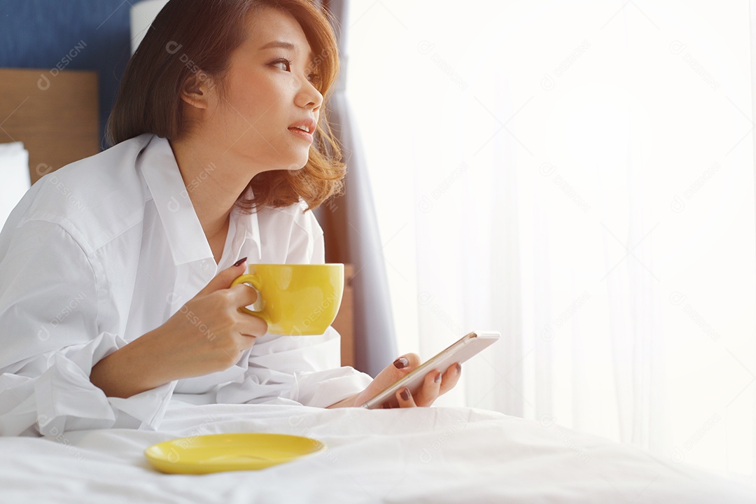 Jovem mulher asiática segurando xícara de café quente ou chá