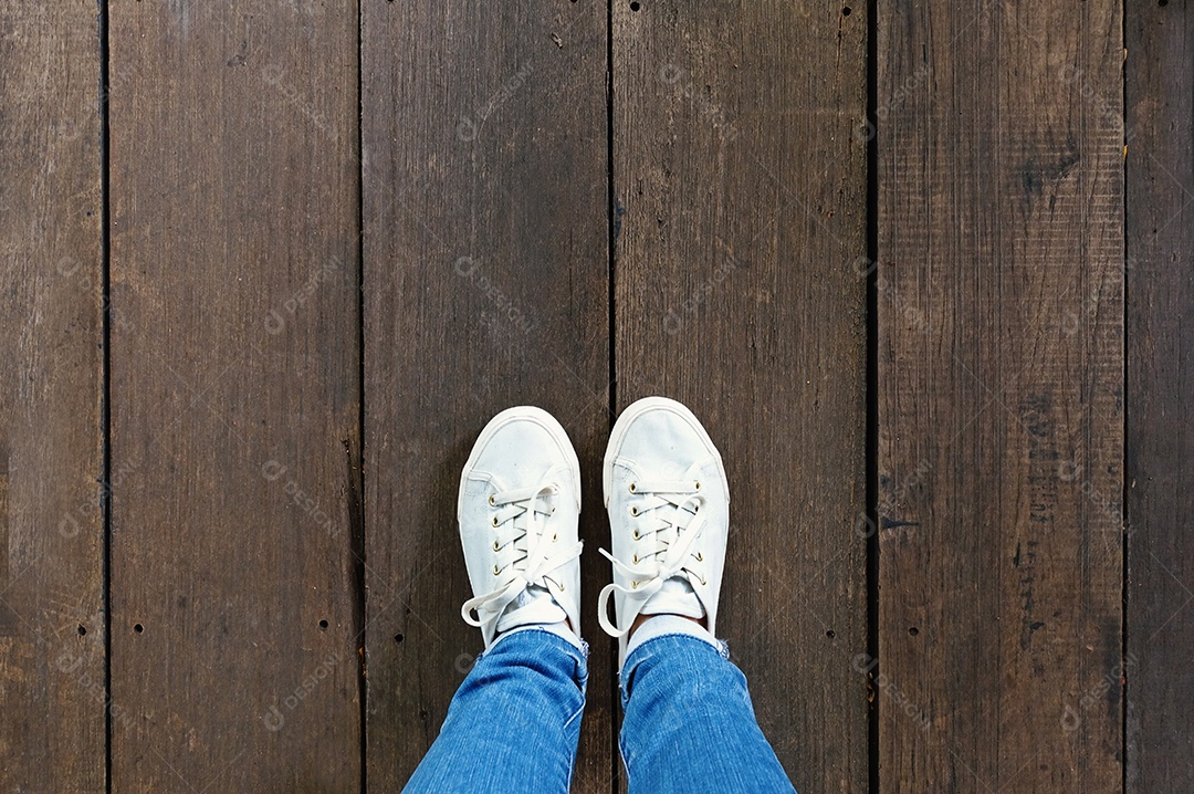 Selfie de pés em tênis da moda no fundo do piso de madeira