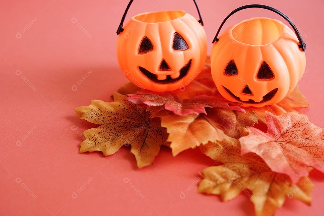 Rosto de abóboras lanterna Jack O nas folhas de outono com fundo laranja