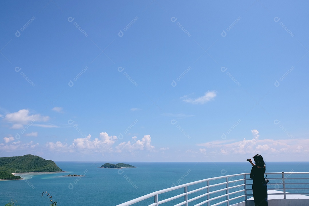 Mulher tirando foto da paisagem do mar