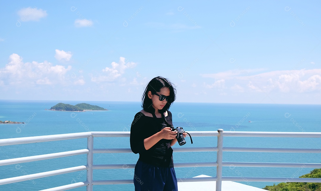 Mulher tirando foto da paisagem do mar