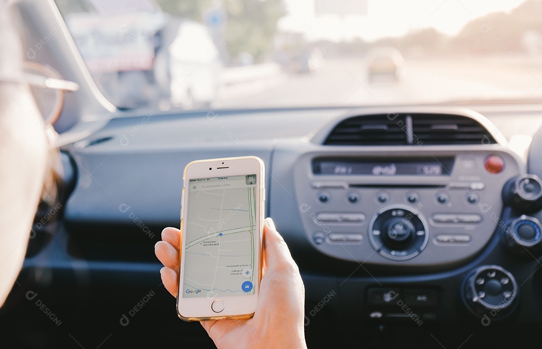Mão segurando o Apple iPhone6s mostrando a rota do Google Maps no carro