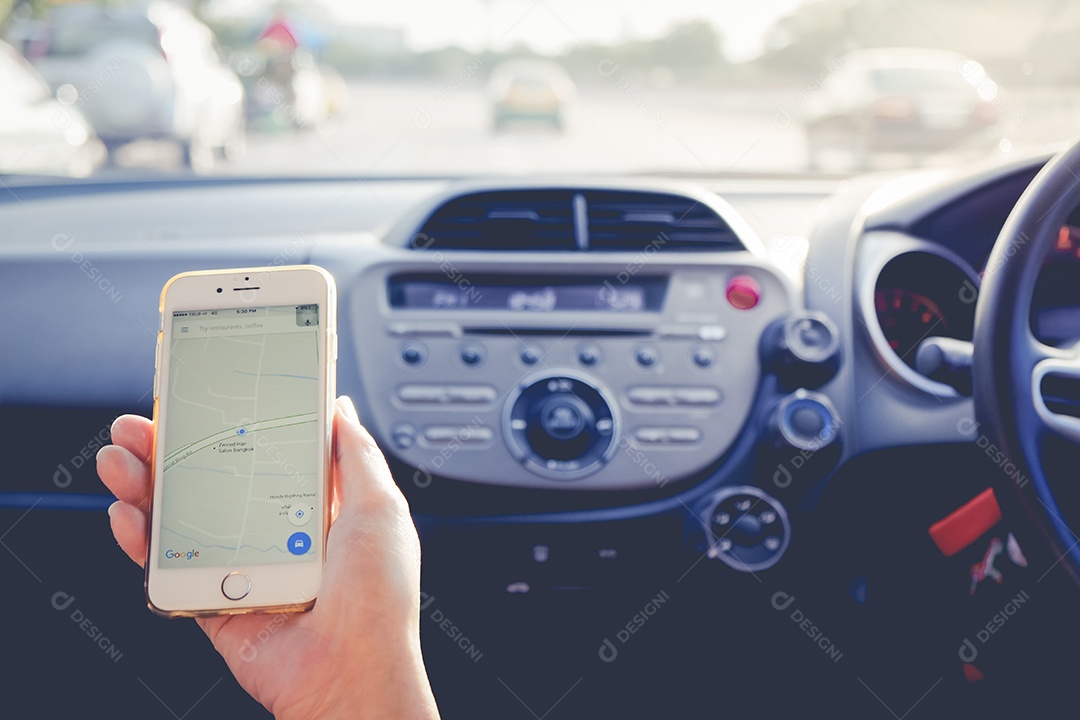 Mão segurando o Apple iPhone6s mostrando a rota do Google Maps no carro