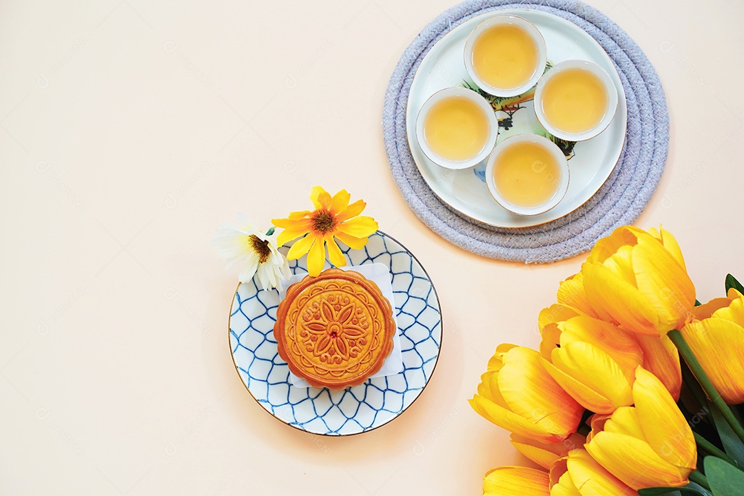 Postura plana de bolo de lua chinês com chá quente e flor em amarelo