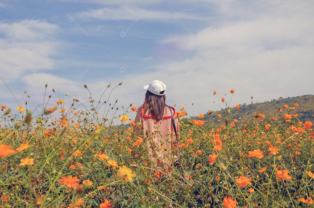 Mulher de estilo de vida feliz parada no campo de flores amarelas no dia ensolarado, filtro estilo retrô, fundo de primavera e verão