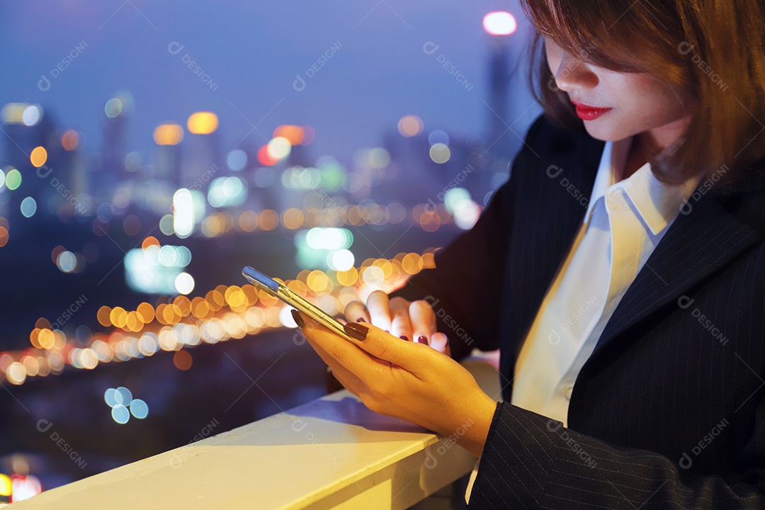 Mulher asiática sacada prédio usando celular