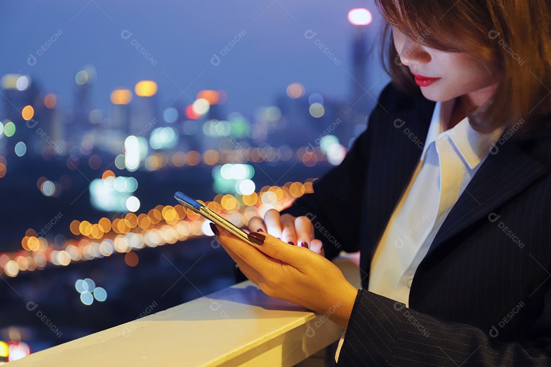 Mulher asiática sacada prédio usando celular