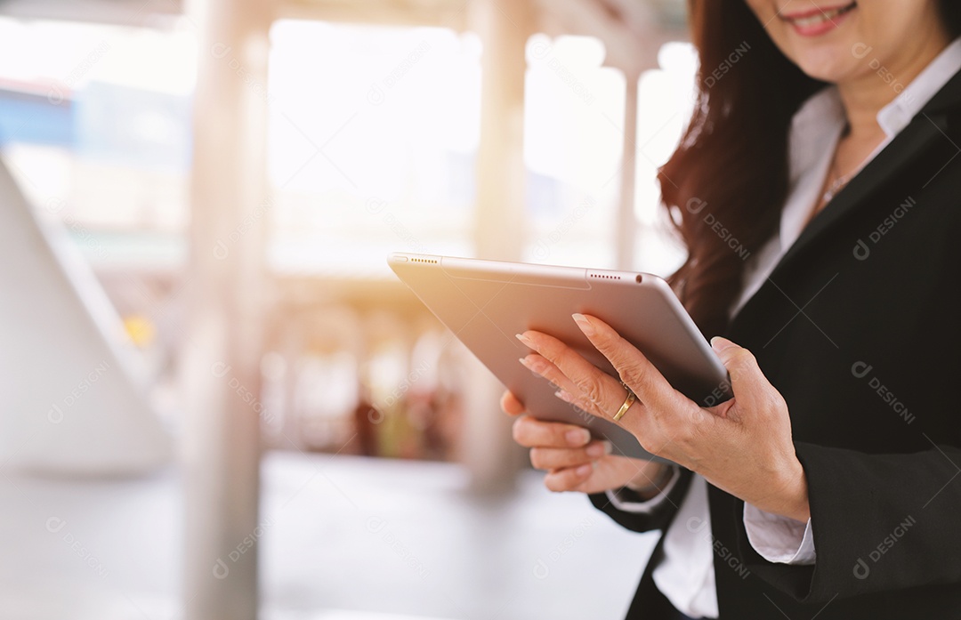 Empresária sênior asiática sorrindo enquanto usava um tablet digital