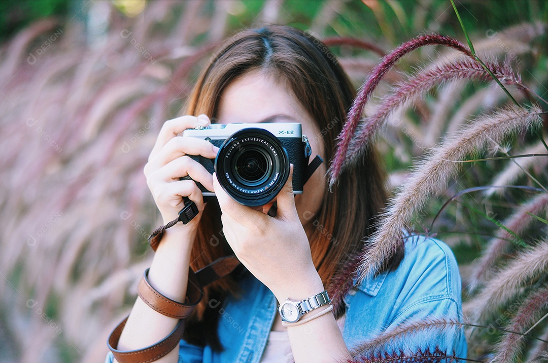 Mulher fotografa em meio ao campo