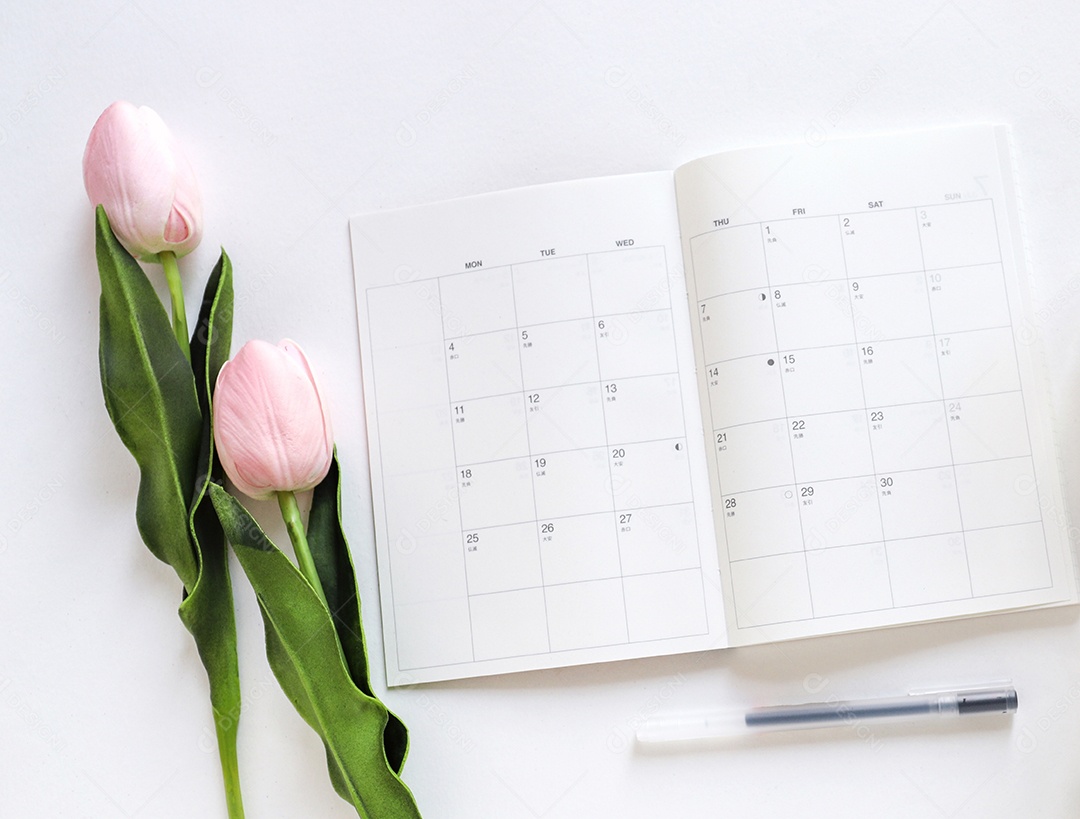 Agenda aberta em mesa com decoração de flores