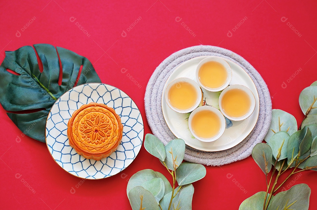 Postura plana de bolo de lua chinês com chá quente e planta verde