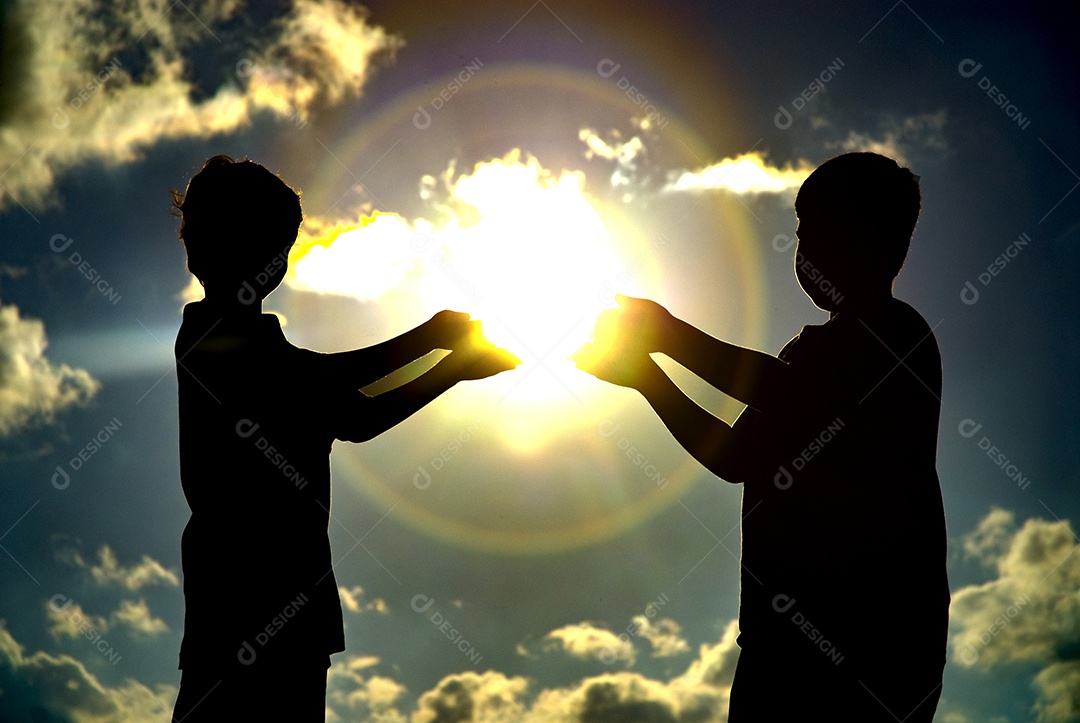 Imagem de duas crianças com as mãos contra o sol fazendo sombras