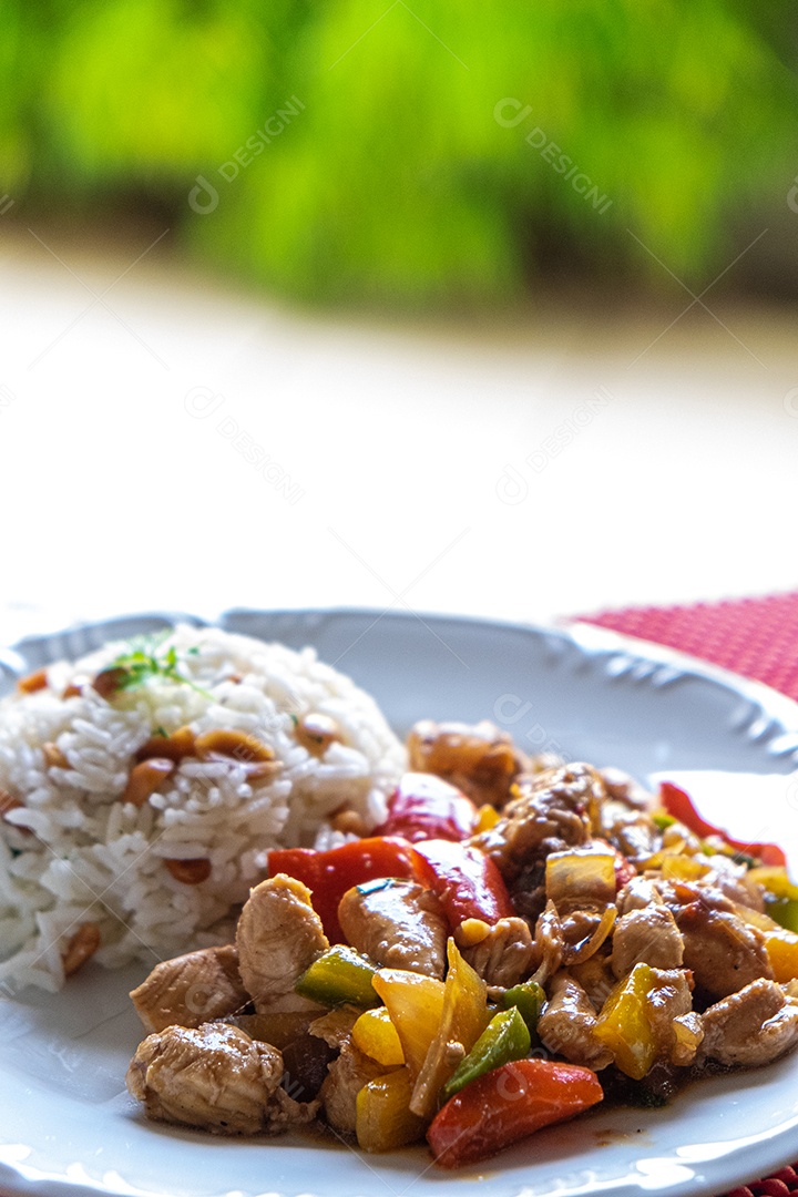 frango xadrez, comida típica chinesa servida com frango e pimentão, amendoim e arroz.