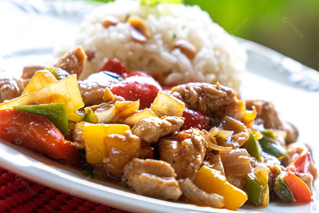 frango xadrez, comida típica chinesa servida com frango e pimentão, amendoim e arroz.