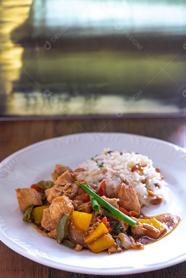 frango xadrez, comida típica chinesa servida com frango e pimentão, amendoim e arroz.