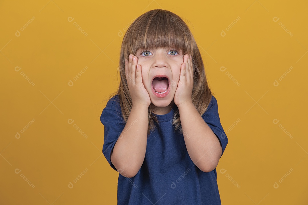 Excited girl screaming on yellow background.