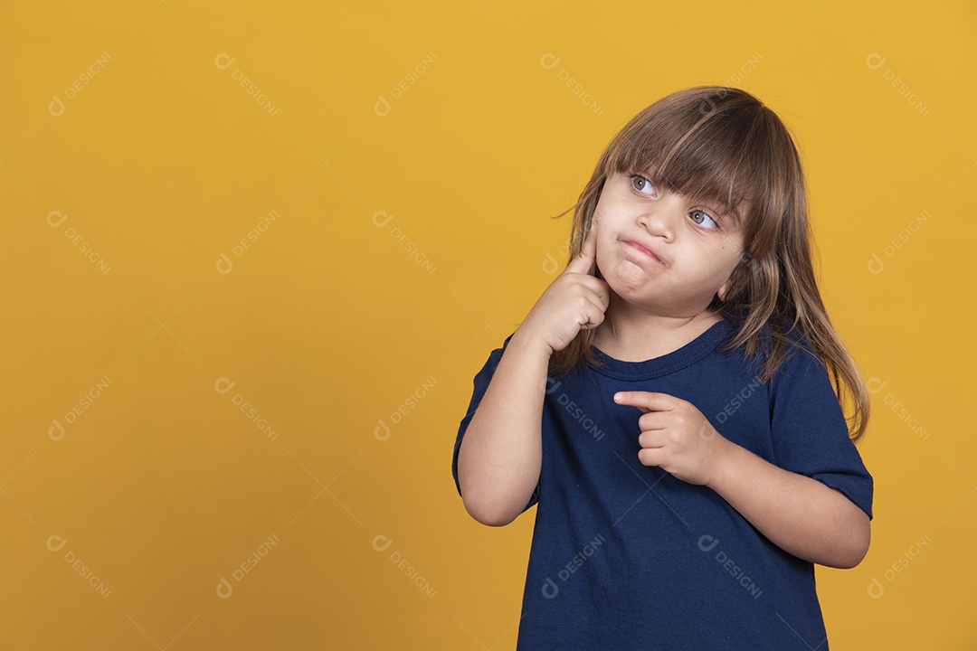adorável garota caucasiana pensando em fundo amarelo