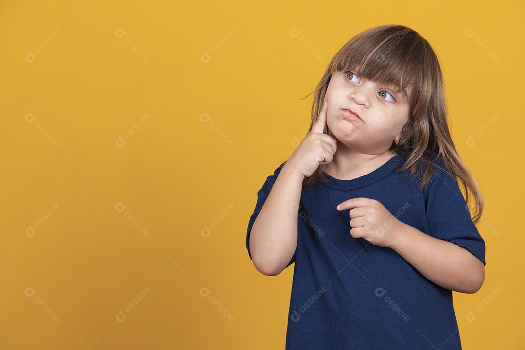 adorável garota caucasiana pensando em fundo amarelo