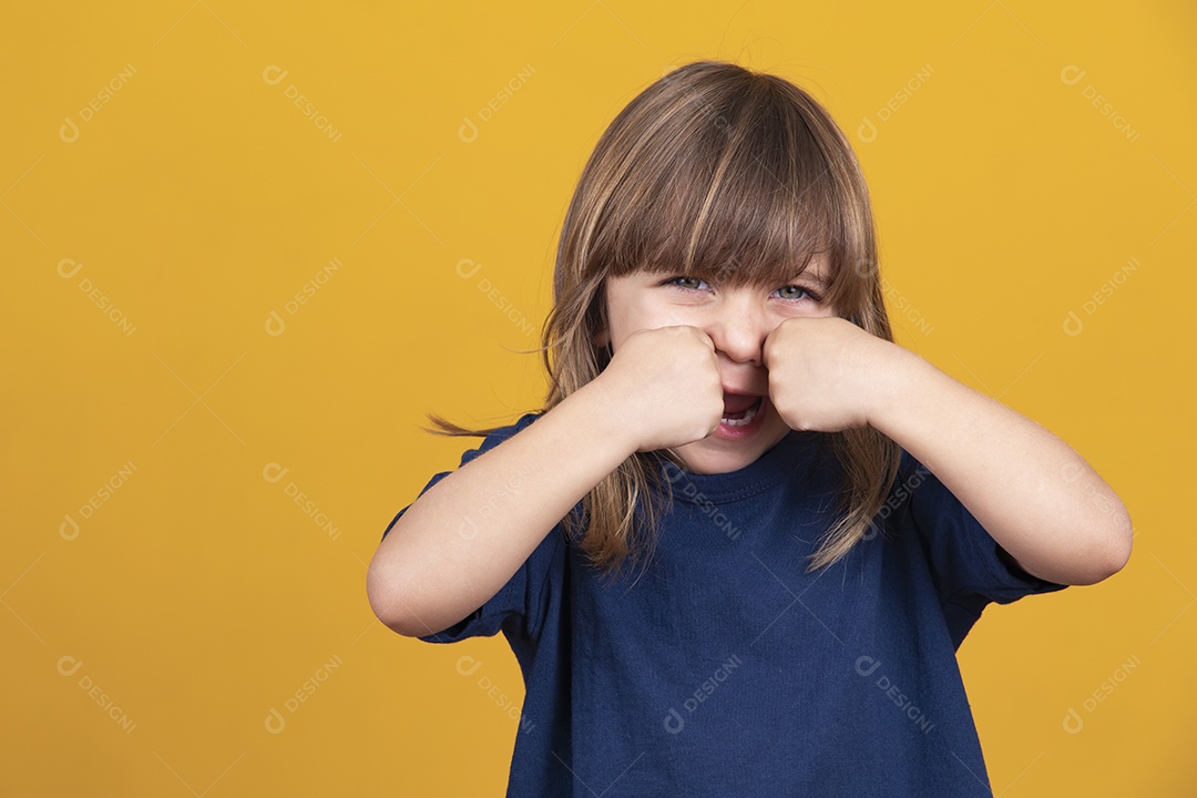 Menina chorando em fundo amarelo