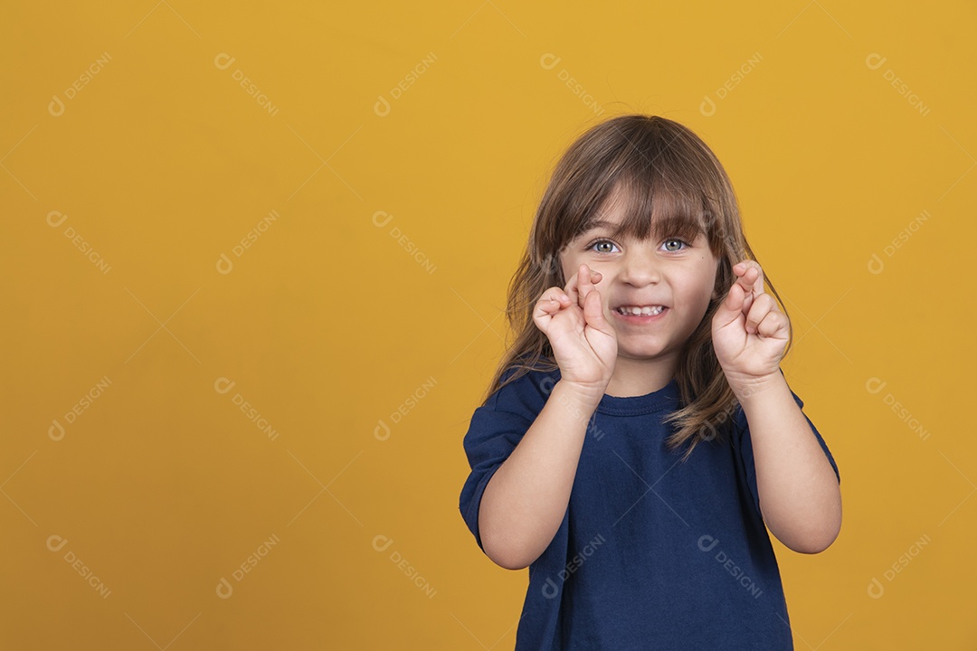 linda criança garota caucasiana com os dedos cruzados desejando sorte