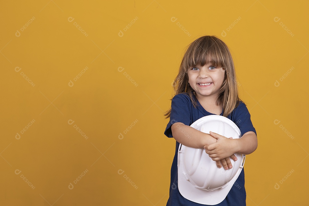 garota com ferramentas de construção. Menina com um capacete de segurança e proteção infantil. Menina bonitinha