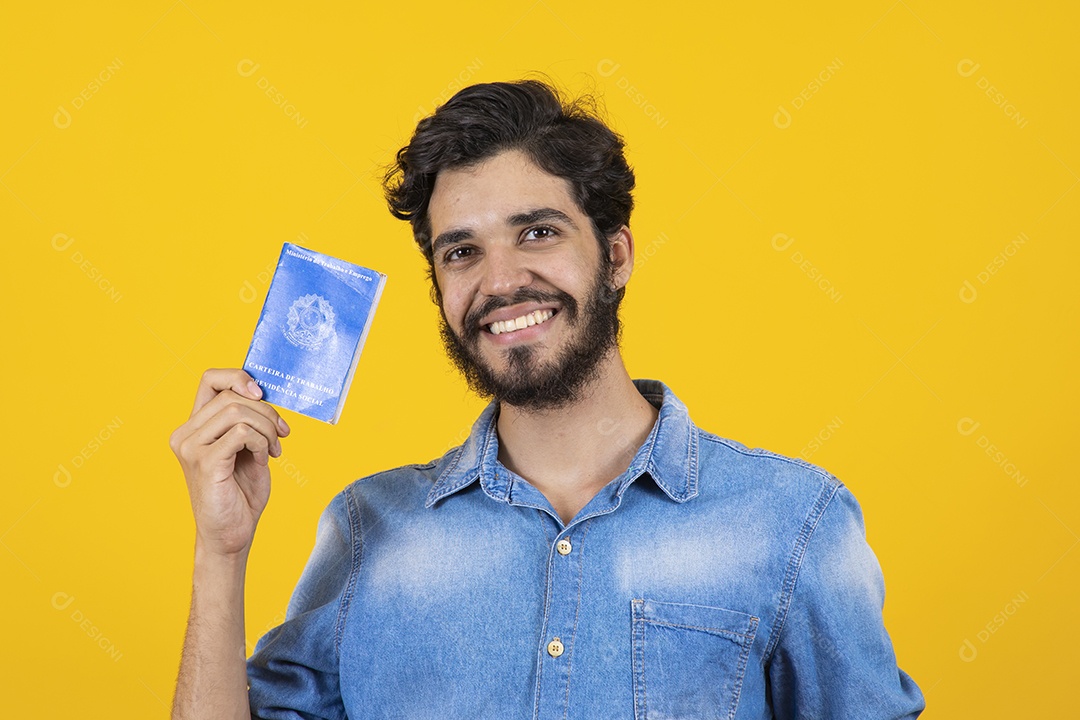 Homem jovem barbudo segurando carteira de trabalho sobre fundo amarelo