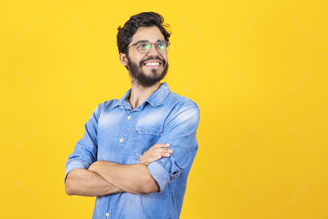 Homem jovem braços cruzado barbudo sobre fundo amarelo